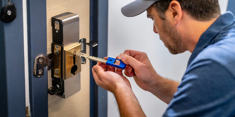 A locksmith testing a newly cut modern key in a contemporary lock.